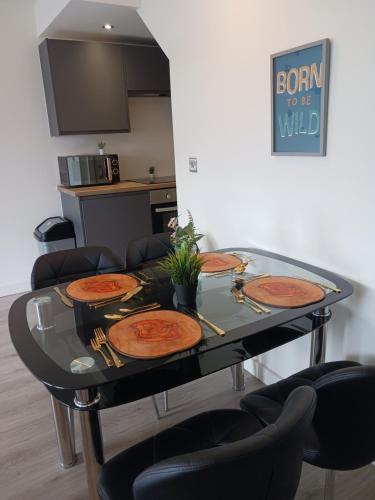 a glass table with four pizzas on top of it at Bliss Apartments - Contractor 314 in Bradford