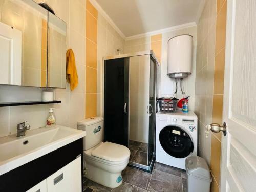 a bathroom with a toilet and a sink and a washing machine at altınkum da denize 150 m 4+1 dublex in Didim