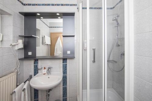 a bathroom with a sink and a shower at Johannesbad Hotel Füssinger Hof in Bad Füssing