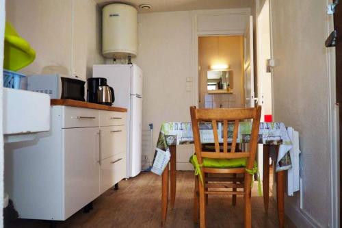 ラ・ブルブールにあるAppartement d'une chambre avec vue sur la ville jardin clos et wifi a La Bourbouleのキッチン(テーブル、椅子、冷蔵庫付)