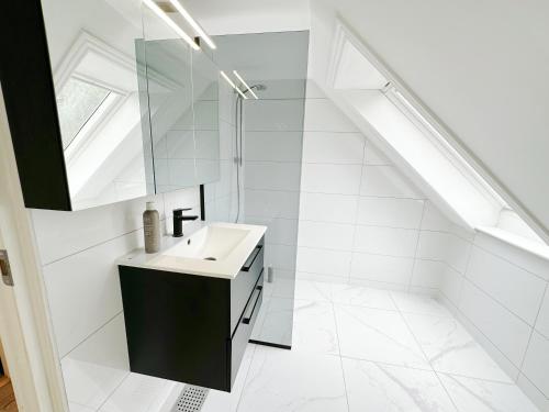 uma casa de banho branca com um lavatório e um espelho em Aalborg city center newly renovated house em Aalborg