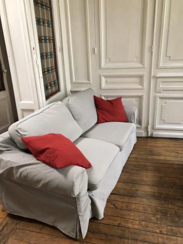 biała kanapa z czerwonymi poduszkami w pokoju w obiekcie Hyper Centre LILLE appt. 6 personnes confortable pour famille ou amis w Lille