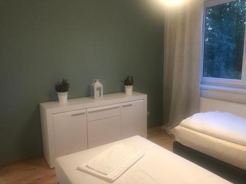 a room with a white cabinet with plants on it at Pokoje gościnne na Miłej in Kochlice