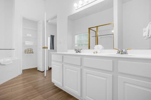 a white bathroom with two sinks and a mirror at Bahama Bay, Davenport, Florida Oversize 2 Br condo in Kissimmee