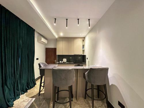 a kitchen with a table and two bar stools at Qlets Privé in Abuja