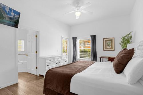 Bahama Bay, Davenport, Florida Oversize 2 Br condo في كيسيمي: غرفة نوم بيضاء بها سرير ونافذة