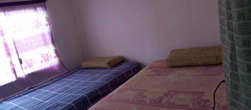 a small room with two beds and a window at Casa Ayangue in Santa Elena