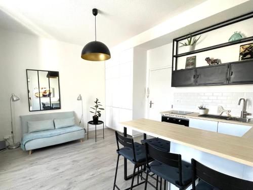 une cuisine et un salon avec une table et un canapé dans l'établissement Charmant T2 Saint Raphael centre historique, à Saint-Raphaël