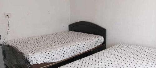 two twin beds in a corner of a room at Casa Ayangue in Santa Elena