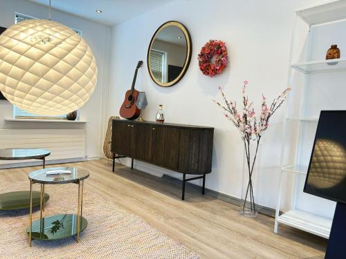 a living room with a guitar and a mirror at Aalborg city center newly renovated house in Aalborg