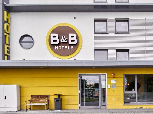 ein gelbes und weißes Gebäude mit einem b b in der Unterkunft B&B Hotel Frankfurt-Nord in Frankfurt am Main