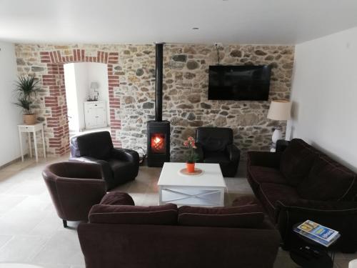 uma sala de estar com sofás e uma parede de pedra em Chambres d'Hôtes des Hirondelles em Beaussais sur Mer