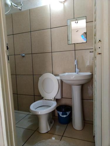 a bathroom with a toilet and a sink at GRAN HOTEL in Três Lagoas