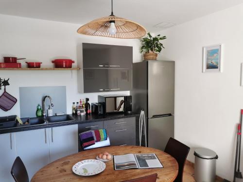 une cuisine avec une table en bois et un réfrigérateur dans l'établissement La Petite Maison, à Arles