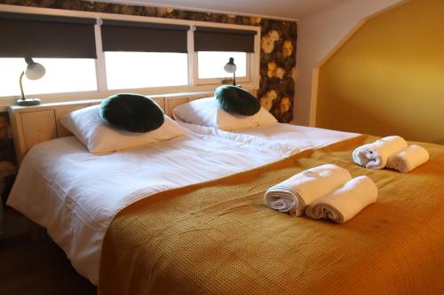 a bedroom with two beds with towels on them at Porcus Campus in Aarle-Rixtel