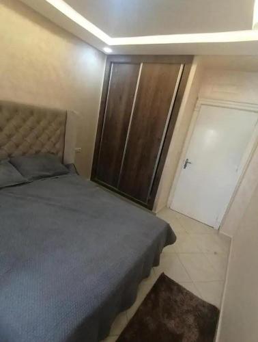 a bedroom with a bed and a closet and a door at Dayar arrid in Nador