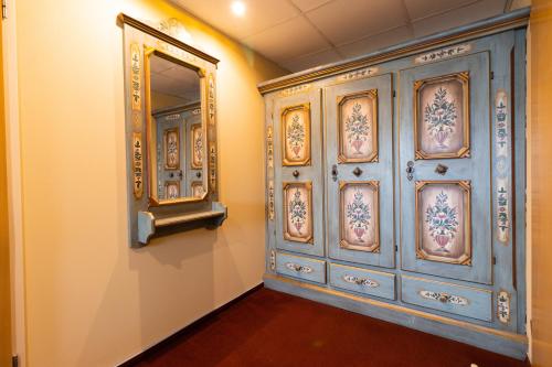 a room with a mirror and a blue wall at Aquamarina Hotel Visegrád in Visegrád