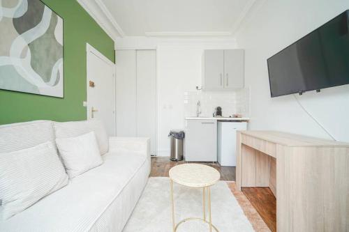 un salon avec un canapé blanc et une télévision dans l'établissement Apartment proche Vaugirard - Sauge - II, à Paris