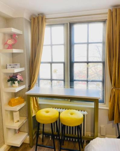 a kitchen with two yellow stools at a counter with a window at Lovely HotelStyle Apartment - Central London in London