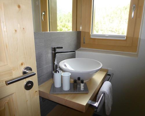 ein Bad mit einem weißen Waschbecken und einem Fenster in der Unterkunft Hotel Roseg-Gletscher in Pontresina