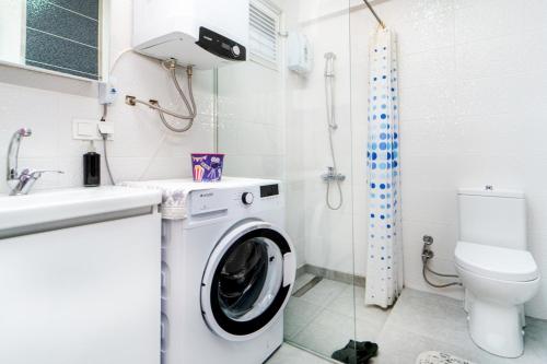 ein Badezimmer mit einer Waschmaschine und einem WC in der Unterkunft Vacation Flat w Pool Garden in Bodrum in Milas