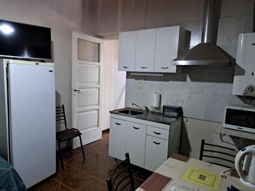 a small kitchen with a white refrigerator and a table at Terra in San Juan