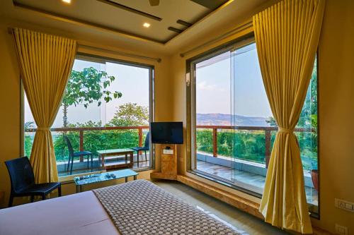 a bedroom with a bed and a large window at hotel saptarang residency panhala in Panhāla