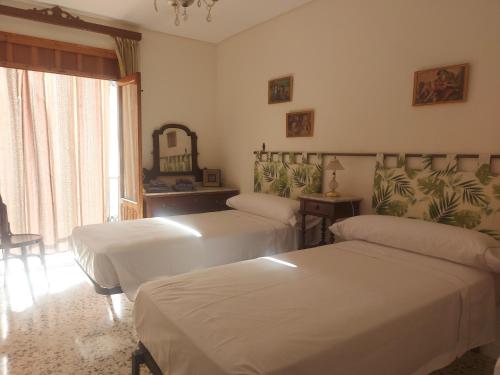 a room with three beds and a mirror on the wall at Balcón de Aguilar in Aguilar de la Frontera