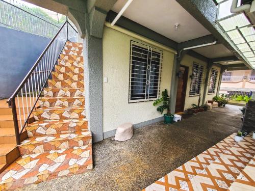 a house with a staircase and a window at Mirador Modern House - Walking distance to Lourdes Grotto in Baguio