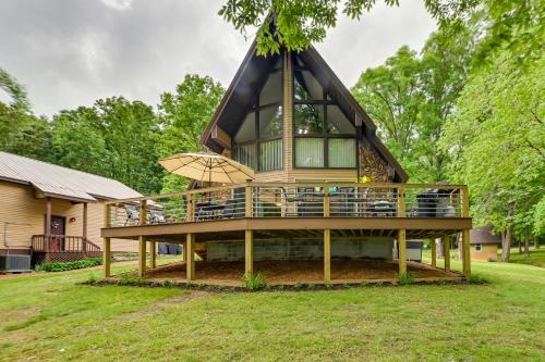 a house with a large deck with an umbrella at Cozy Dover Home with Boat Dock, Fire Pit and Deck! in Dover