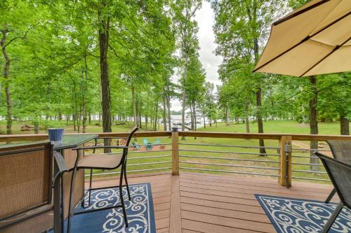 a wooden deck with a table and chairs and trees at Cozy Dover Home with Boat Dock, Fire Pit and Deck! in Dover