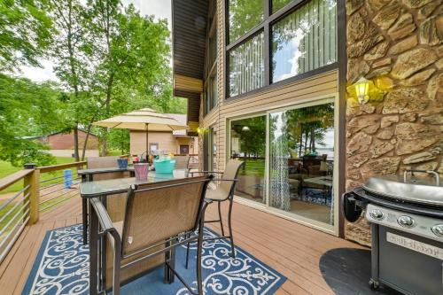 an outdoor kitchen with a table and a grill on a deck at Cozy Dover Home with Boat Dock, Fire Pit and Deck! in Dover