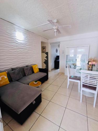 a living room with a couch and a table at COQUET F2 CLIMATISE AVEC PISCINE AU LAMENTIN in Le Lamentin