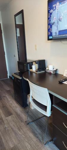 a desk with a chair and a tv on a wall at Microtel Inn & Suites by Wyndham Hoover/Birmingham in Hoover