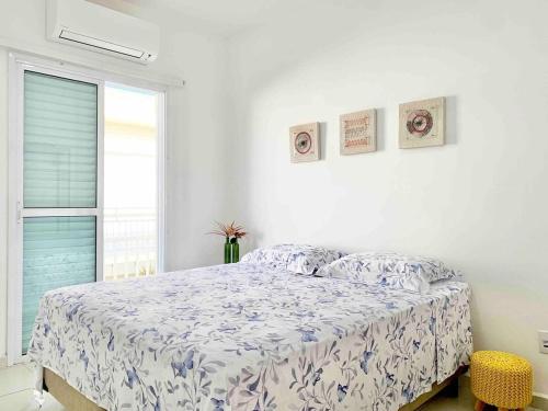 ein weißes Schlafzimmer mit einem Bett und einem Fenster in der Unterkunft Casa Marola: 100M da Praia, Completa e Tranquila in Bertioga