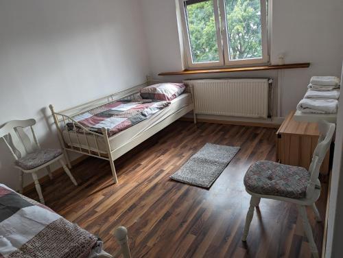 a bedroom with a bed and two chairs and a desk at Gästehaus Gröpelingen in Bremen