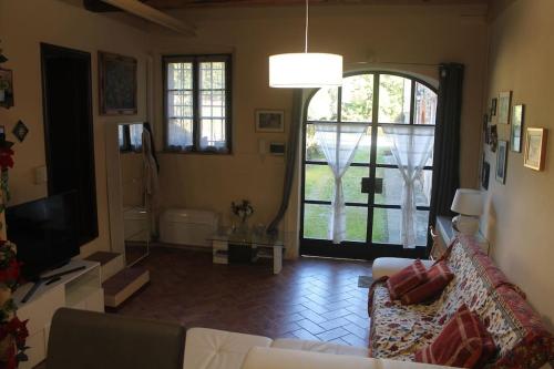 a living room with a couch and a large window at Il Guscio in Corsanico-Bargecchia