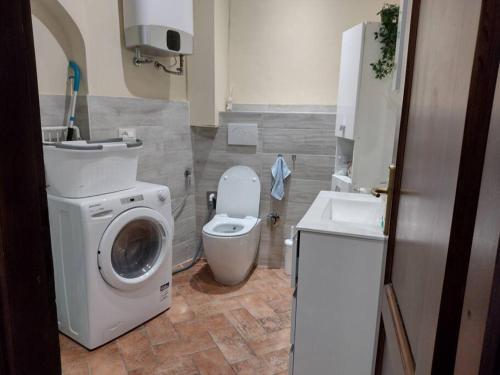 a bathroom with a toilet and a washing machine at Il Guscio in Corsanico-Bargecchia