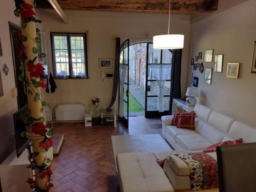 a living room with white furniture and a large window at Il Guscio in Corsanico-Bargecchia