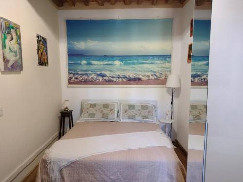 a bedroom with a bed with a painting on the wall at Il Guscio in Corsanico-Bargecchia