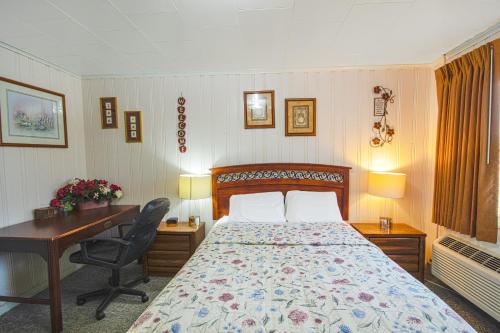a bedroom with a bed and a desk and a desk at Sunflower Motel Hiawatha By OYO in Hiawatha