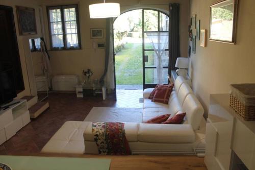 a living room with a white couch and a television at Il Guscio in Corsanico-Bargecchia