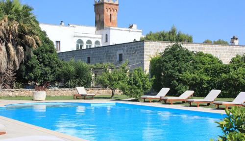 una piscina con tumbonas y un edificio en Masseria Incantalupi, en San Vito dei Normanni