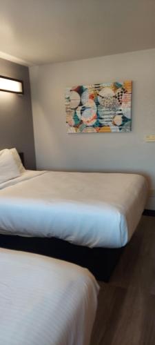 two beds in a hotel room with a painting on the wall at Microtel Inn & Suites by Wyndham Hoover/Birmingham in Hoover