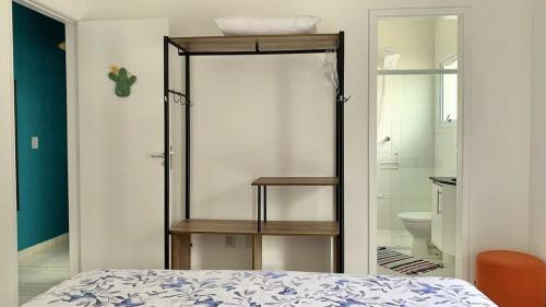 ein Schlafzimmer mit einem Bett und ein Badezimmer mit einer Toilette in der Unterkunft Casa das Marés: 100M Praia da Enseada - Tranquila e Completa in Bertioga