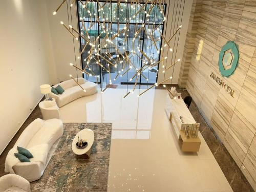 a living room with white furniture and a large window at 1 Bed Modern Apartment, Pool, Gym, Cinema in Lahore