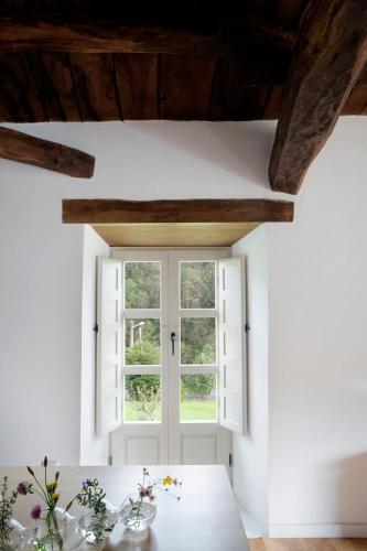 a room with a window and a table at Casa de las Flores / Casa de campo LUGO in A Pontenova