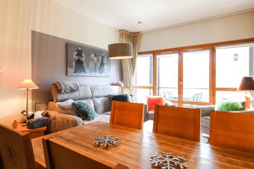 un salon avec une table et un canapé dans l'établissement Joli, spacieux appartement T3 sud ski aux pieds, parking, à Flaine