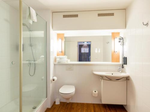 uma casa de banho com um WC, um lavatório e um chuveiro em B&B Hotel Duisburg Hbf-Nord em Duisburg