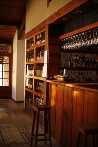 a bar with two stools in a room with alcohol at Fazenda Capuava in Bananal